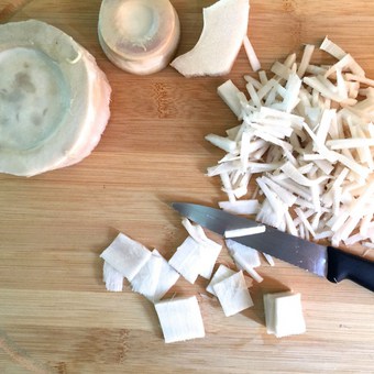 Rounds of bamboo shoots being sliced into thin juliennes for making curry